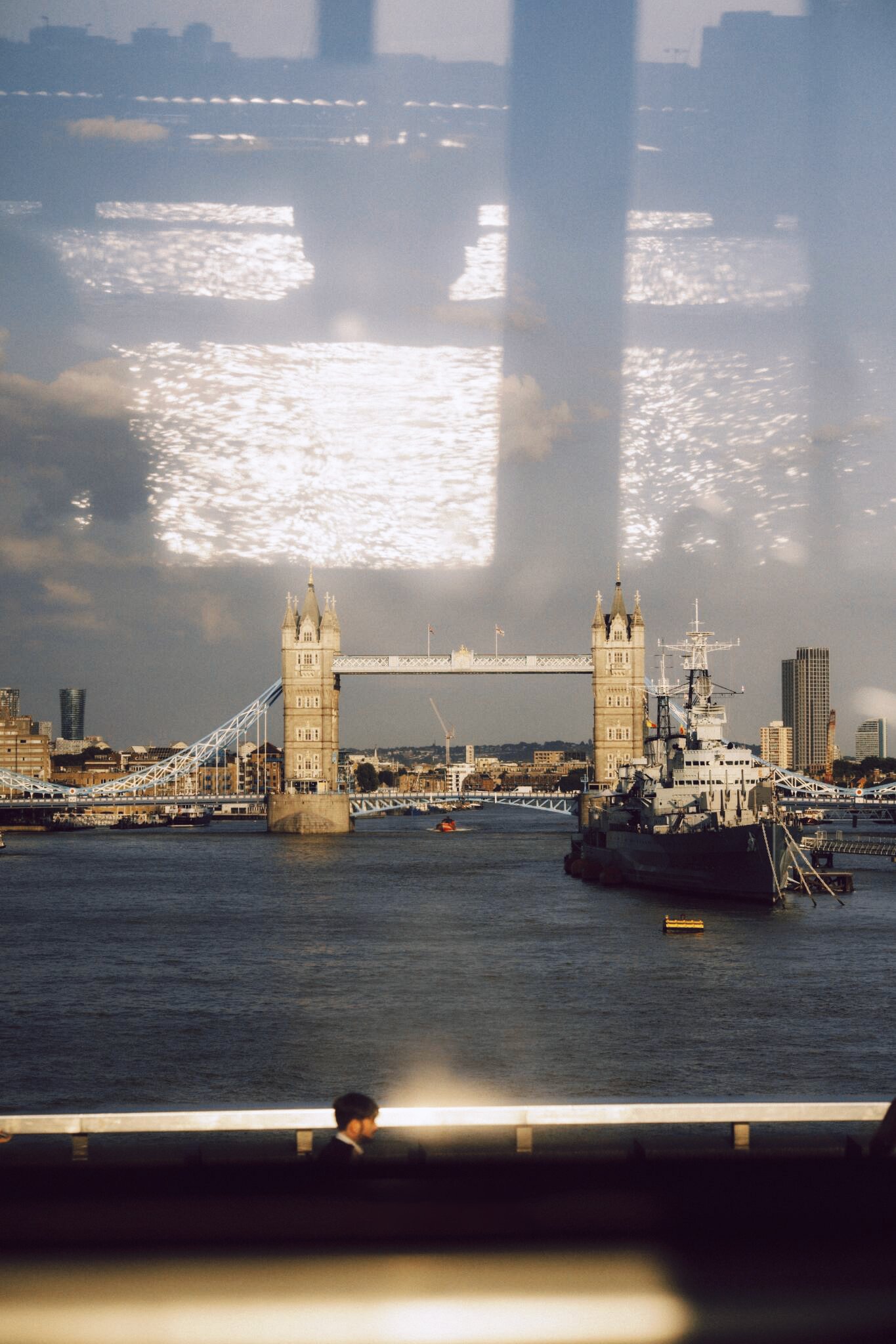 Tower Bridge and a moored ship on the Thames, seen through glass reflections